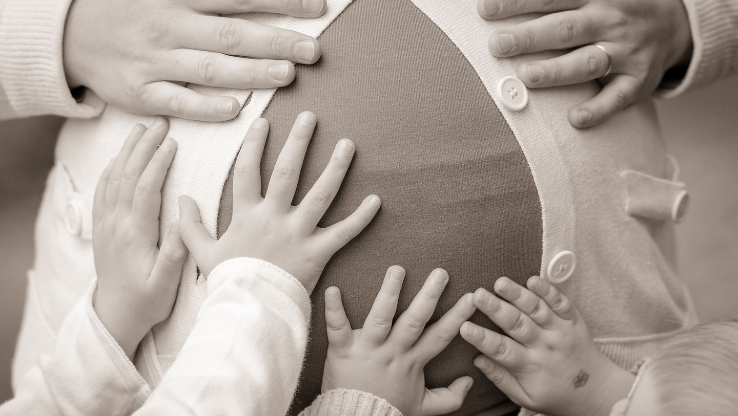 Photographie originale : les mains de la famille sur un ventre de grossesse